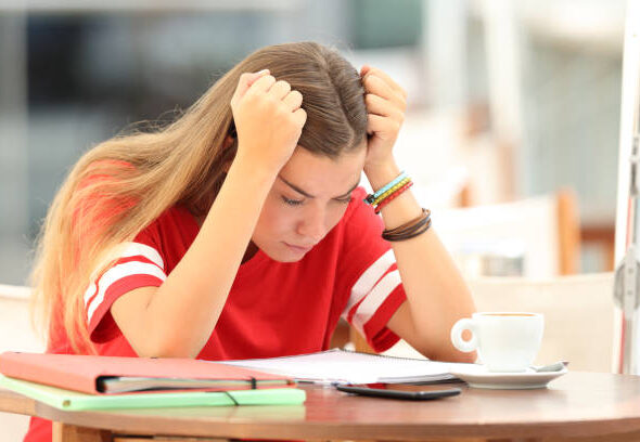 Single frustrated student girl trying to understand notes sitting in a bar
